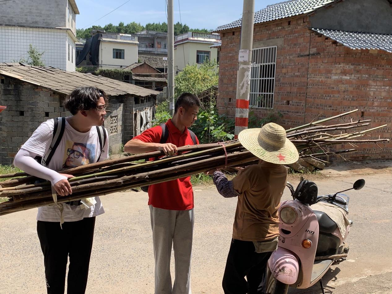 觀察團成員幫助村民搬運重物
