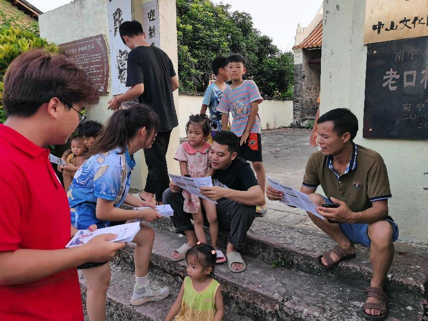 實踐團成員在宗祠前發放宣傳手冊講解龍獅運動